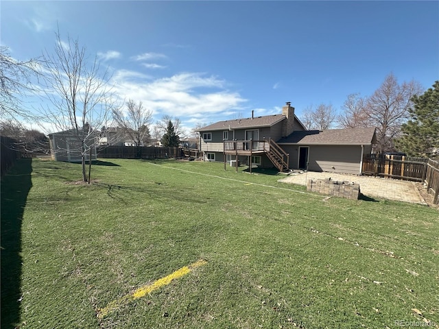 view of yard with stairway, a deck, and a fenced backyard