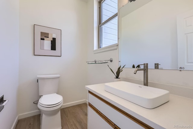 2120 W 31st Ave, Denver, CO 80211 - half bathroom featuring toilet, baseboards, vanity, and wood finished floors