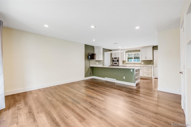 16135 E Baker Pl, Aurora, CO 80013 - unfurnished living room featuring light wood-style flooring and recessed lighting