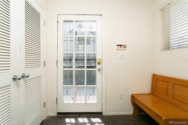 doorway to outside with dark tile patterned floors