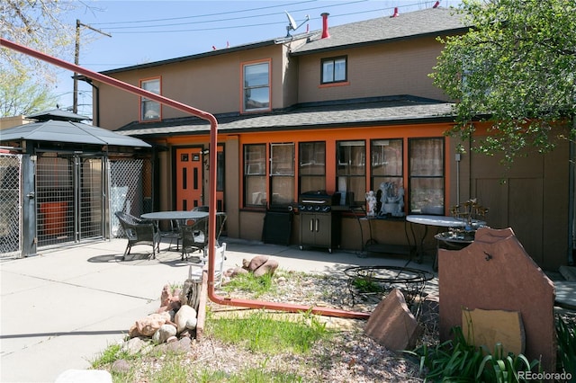 rear view of house featuring a gazebo and a patio area