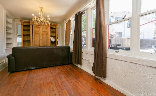 unfurnished living room with a chandelier and dark hardwood / wood-style floors