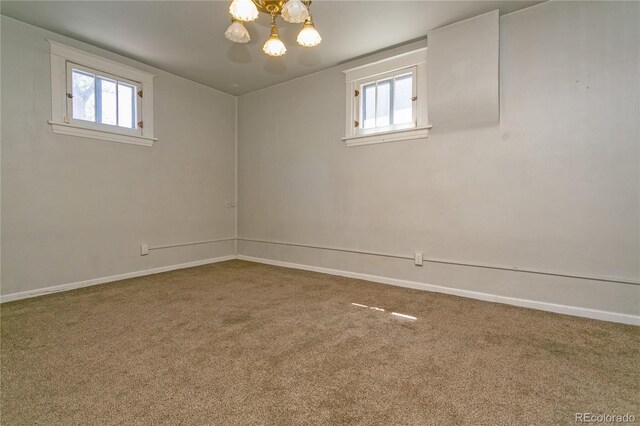 unfurnished room featuring carpet flooring, a wealth of natural light, and a notable chandelier