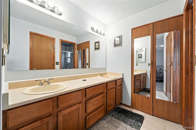 8468 S Upham Way, Littleton, CO 80128 - bathroom featuring ensuite bathroom, double vanity, tile patterned flooring, and a textured ceiling