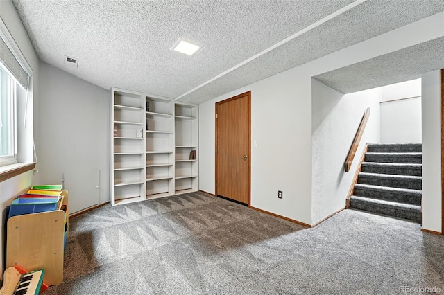 8468 S Upham Way, Littleton, CO 80128 - below grade area featuring a textured ceiling, carpet flooring, and stairs