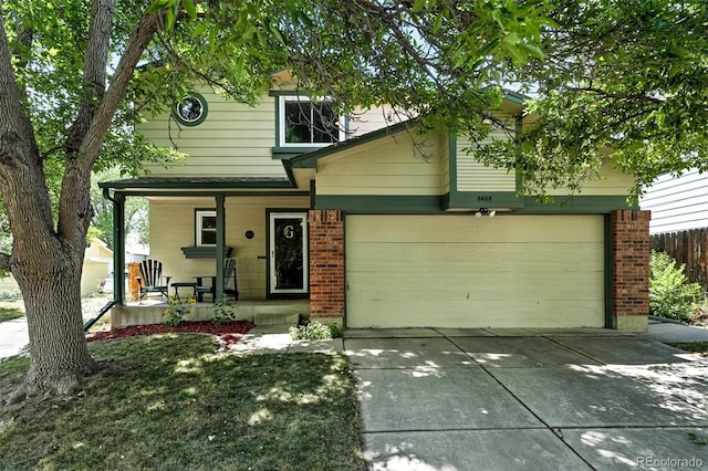 8468 S Upham Way, Littleton, CO 80128 - view of front facade with a porch, brick siding, concrete driveway, and a garage