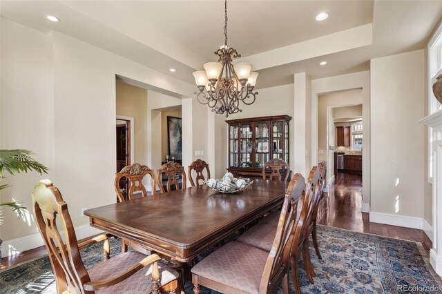 dining room with recessed lighting, baseboards, an inviting chandelier, and dark wood finished floors