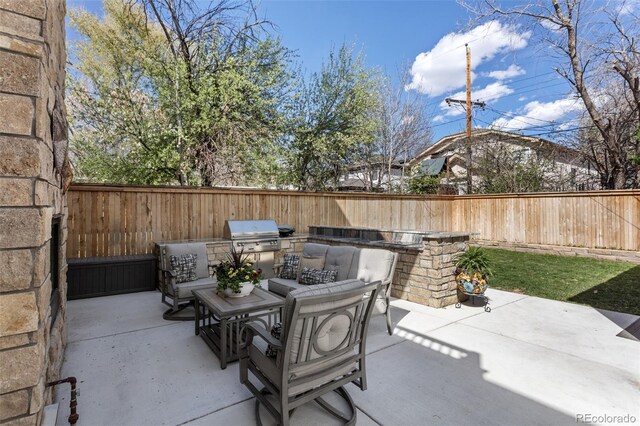 view of patio featuring area for grilling, grilling area, outdoor dining area, and a fenced backyard