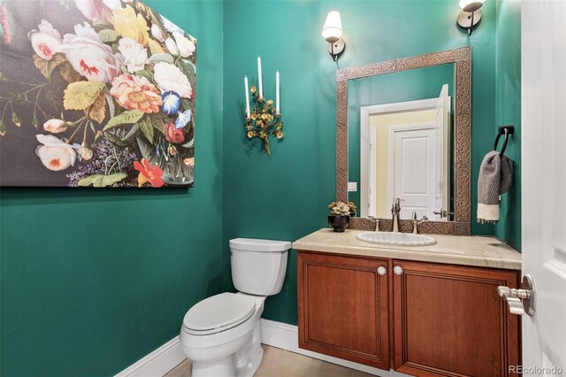 bathroom with vanity, baseboards, tile patterned floors, and toilet