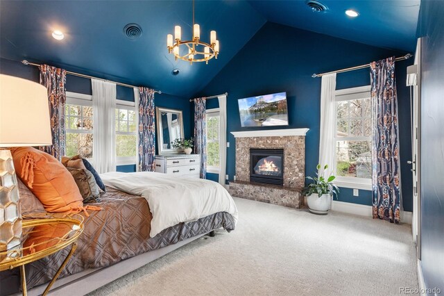 carpeted bedroom with high vaulted ceiling, a chandelier, a stone fireplace, baseboards, and visible vents