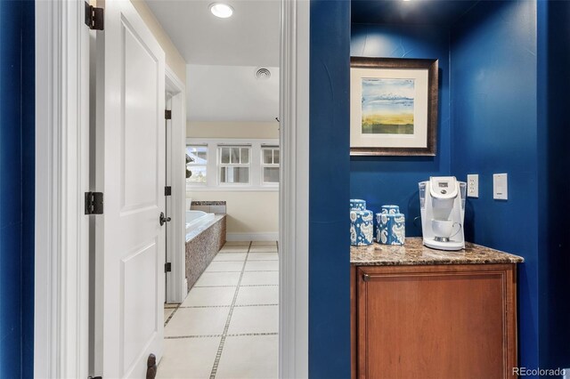 bathroom with a tub, visible vents, tile patterned flooring, and vanity