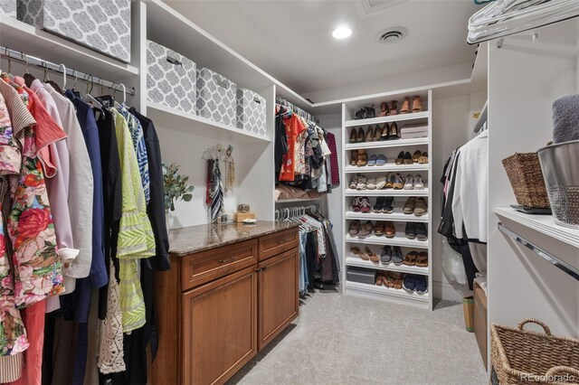walk in closet featuring visible vents and light colored carpet