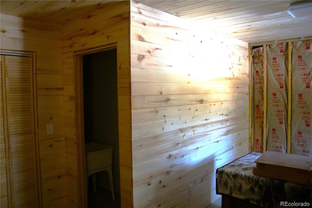 bedroom with wooden walls and wood ceiling