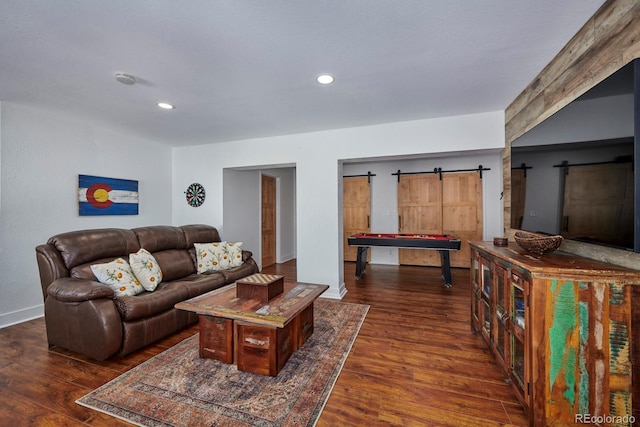 living area with dark wood-type flooring, recessed lighting, and a barn door