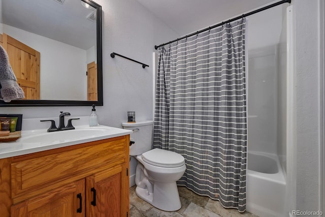 full bath featuring shower / tub combo, stone finish floor, vanity, and toilet