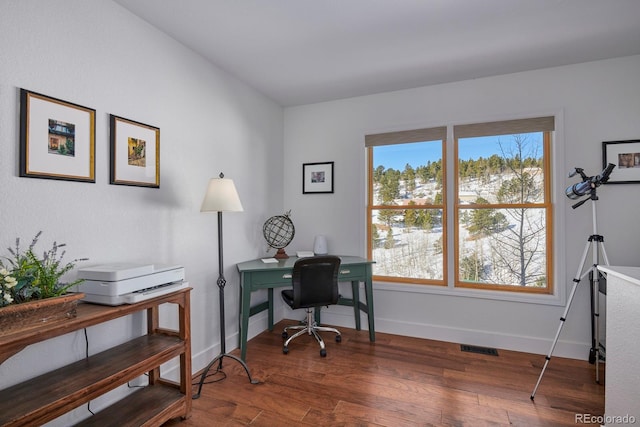 home office with wood finished floors, visible vents, and baseboards