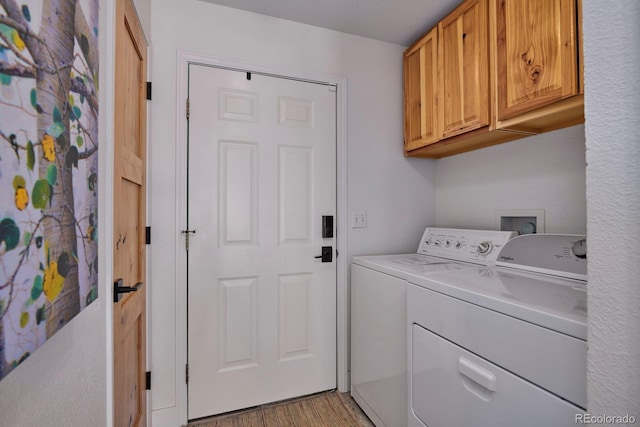 laundry room with cabinet space, washing machine and dryer, and light wood-style flooring