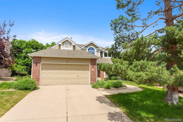 3 Silverberry, Littleton, CO 80127 - view of front of house with brick siding, concrete driveway, an attached garage, and a shingled roof