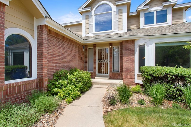 3 Silverberry, Littleton, CO 80127 - view of exterior entry featuring brick siding and a shingled roof