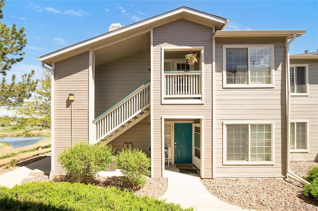 8405 Pebble Creek Way Unit 202, Highlands Ranch, CO 80126 - view of front of home with stairs, a water view, and a chimney