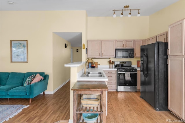 8405 Pebble Creek Way Unit 202, Highlands Ranch, CO 80126 - kitchen featuring black appliances, a sink, open floor plan, and light wood finished floors