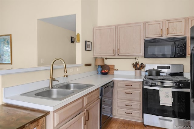 8405 Pebble Creek Way Unit 202, Highlands Ranch, CO 80126 - kitchen with black appliances, light brown cabinets, a sink, and light countertops