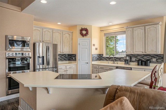 29751 E 163rd Pl, Brighton, CO 80603 - kitchen featuring a sink, tasteful backsplash, a kitchen bar, light countertops, and appliances with stainless steel finishes