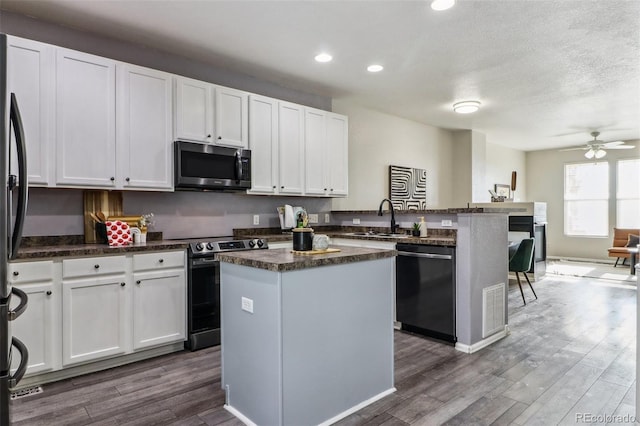 15612 E 96th Way Unit 13E, Commerce City, CO 80022 - kitchen with stainless steel appliances, a sink, a peninsula, dark wood-type flooring, and a kitchen island