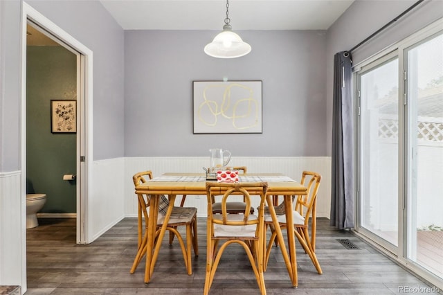 15612 E 96th Way Unit 13E, Commerce City, CO 80022 - dining room featuring a wainscoted wall and dark wood-type flooring