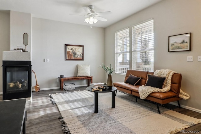 15612 E 96th Way Unit 13E, Commerce City, CO 80022 - living area with wood finished floors, a ceiling fan, a multi sided fireplace, and baseboards