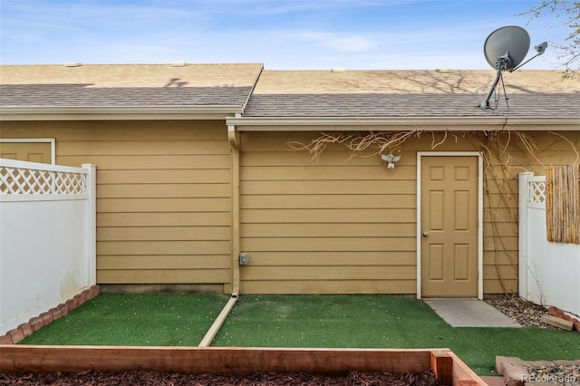 15612 E 96th Way Unit 13E, Commerce City, CO 80022 - view of exterior entry with fence and a shingled roof