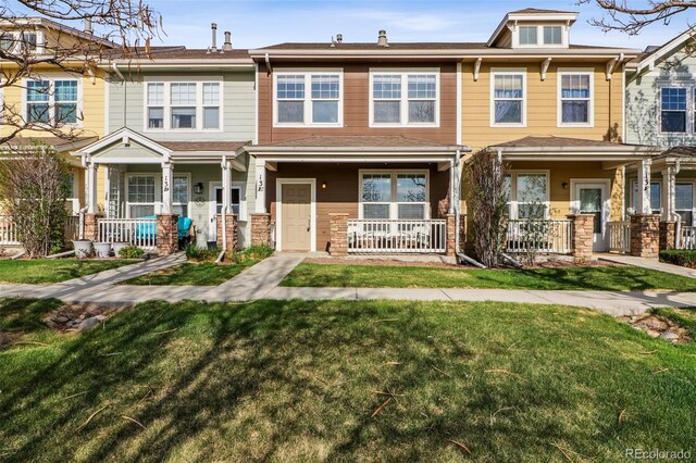 15612 E 96th Way Unit 13E, Commerce City, CO 80022 - view of property with a porch, a front yard, and stone siding