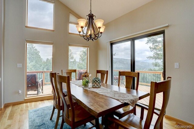 220 Long Ridge Dr, Bailey, CO 80421 - dining area featuring a chandelier, light wood-style floors, a mountain view, and high vaulted ceiling