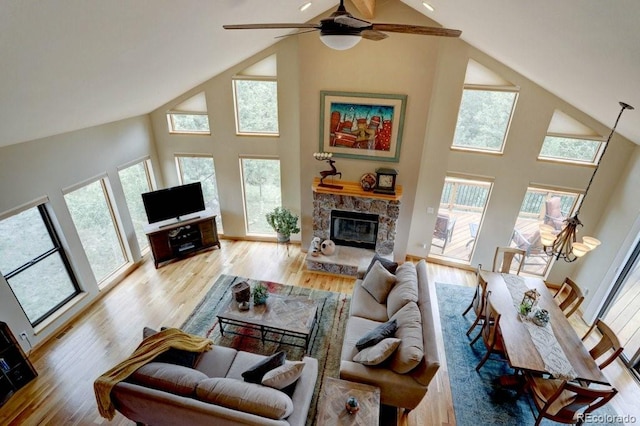 220 Long Ridge Dr, Bailey, CO 80421 - living area with high vaulted ceiling, healthy amount of natural light, a fireplace, light wood-style floors, and a ceiling fan