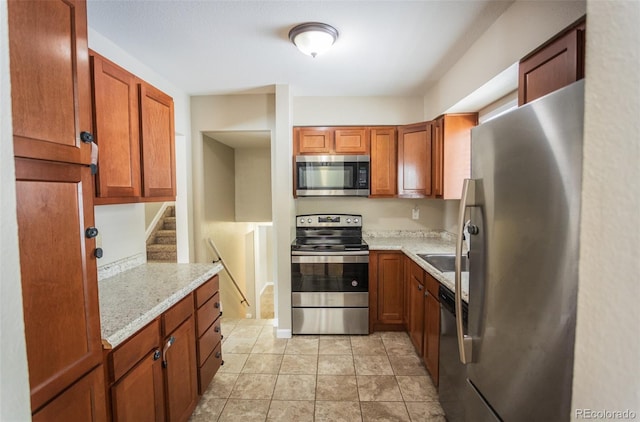 kitchen featuring appliances with stainless steel finishes and light stone counters