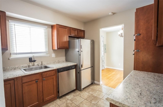 kitchen with light hardwood / wood-style floors, stainless steel appliances, sink, and a chandelier