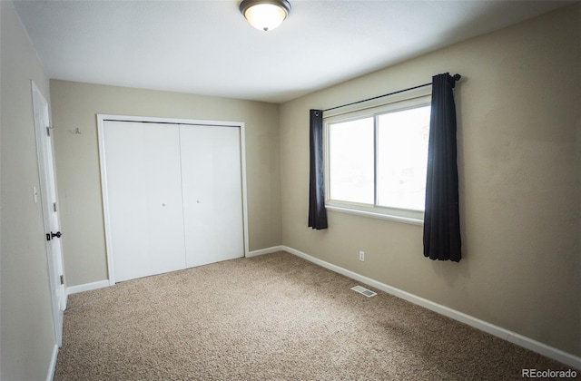 unfurnished bedroom featuring a closet and carpet flooring