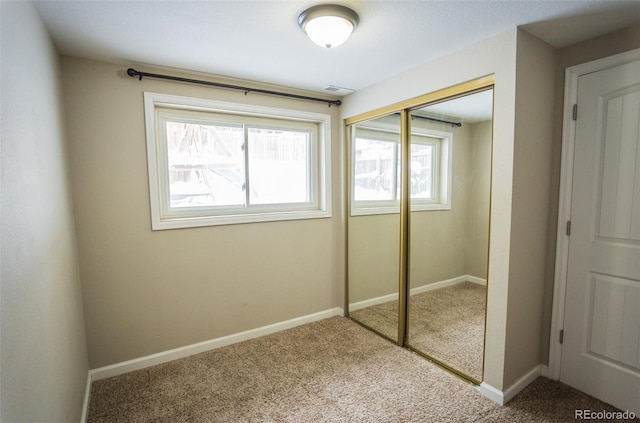 unfurnished bedroom featuring carpet flooring and a closet