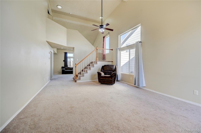 unfurnished room featuring a healthy amount of sunlight, carpet floors, and high vaulted ceiling