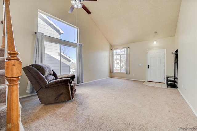 sitting room with carpet floors, high vaulted ceiling, baseboards, and stairway