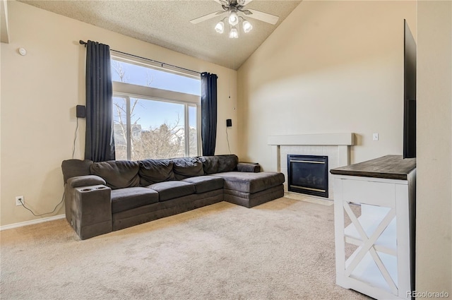 living room featuring baseboards, a tiled fireplace, ceiling fan, a textured ceiling, and carpet flooring