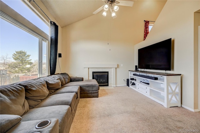 living room with a fireplace, light colored carpet, ceiling fan, high vaulted ceiling, and baseboards