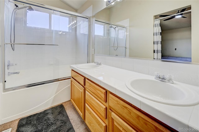 full bath with ceiling fan, shower / bath combination with glass door, a sink, and double vanity