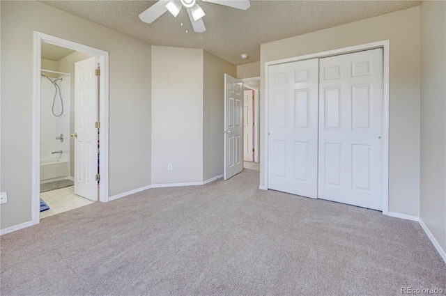 unfurnished bedroom with carpet, a closet, ceiling fan, a textured ceiling, and baseboards