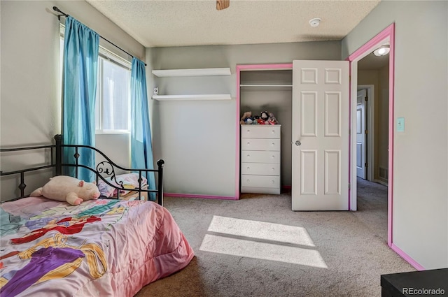 bedroom with carpet, a closet, visible vents, and a textured ceiling