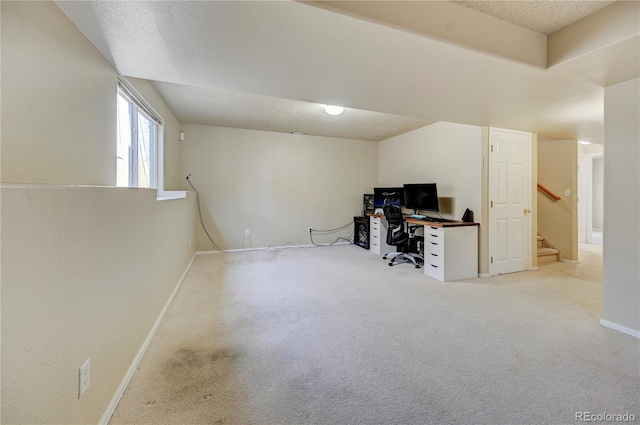 carpeted home office with baseboards and a textured ceiling