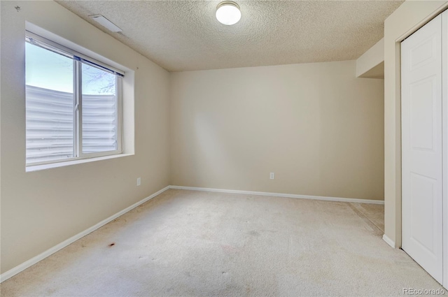 unfurnished bedroom featuring a textured ceiling, a closet, carpet, and baseboards