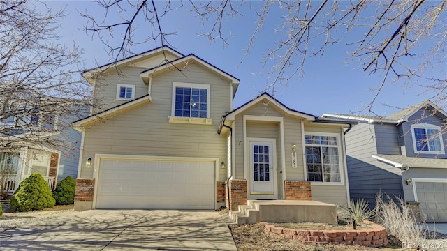 view of front of home featuring an attached garage, concrete driveway, and brick siding