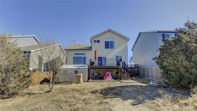 back of property featuring fence, stairway, and a wooden deck