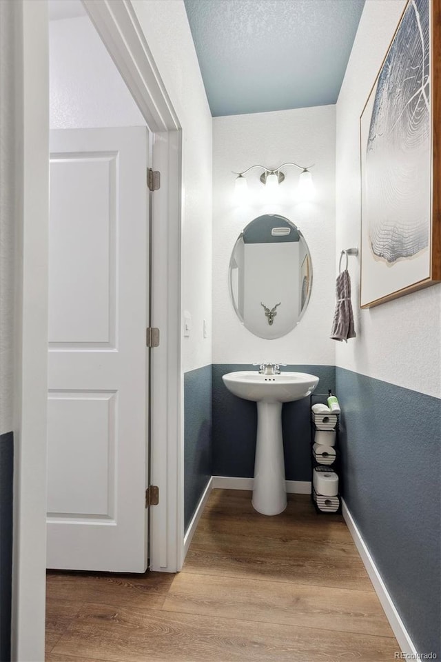 bathroom with wood-type flooring and a textured ceiling